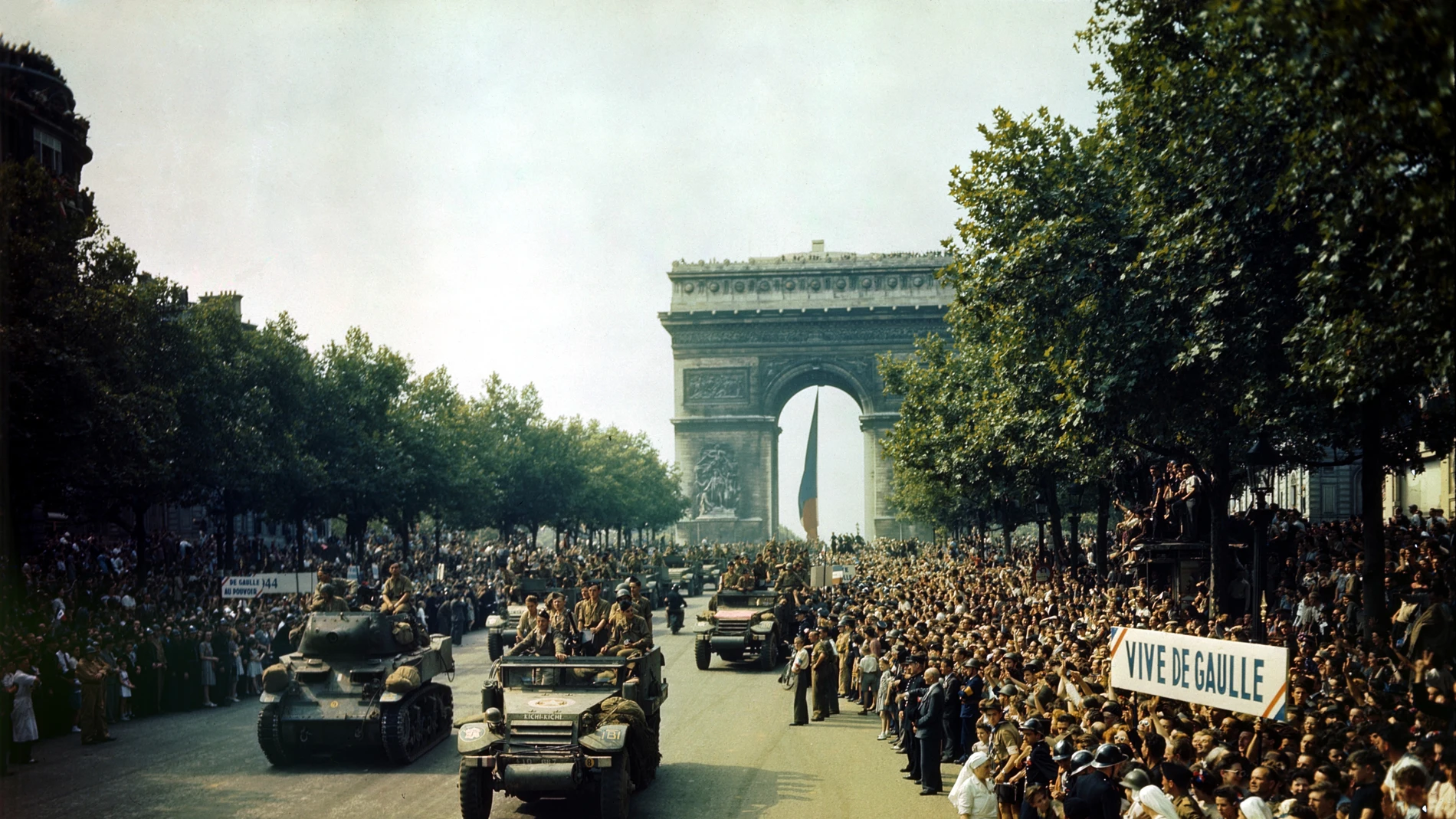 Multitudes de patriotas franceses se alinean en los Campos Elíseos para ver los tanques de la Francia Libre y los semiorugas de la 2.ª División Blindada del general Leclerc pasan por el Arco del Triunfo, después de la liberación de París el 26 de agosto de 1944.