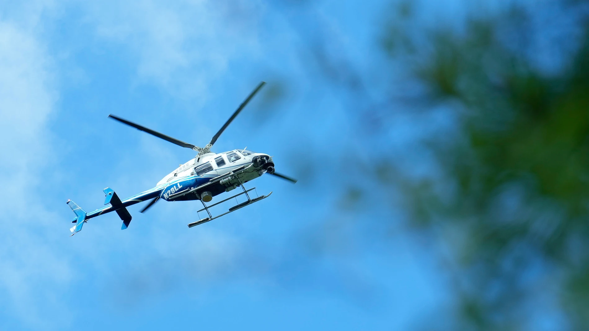 A helicopter flies over a location where law enforcement believe they have cornered a suspect who allegedly shot and killed five people in a house the night before, Saturday, April 29, 2023, in unincorporated San Jacinto County, Texas. (Yi-Chin Lee/Houston Chronicle via AP)
