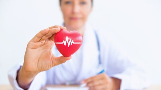 Portrait of woman doctor with holding red heart.