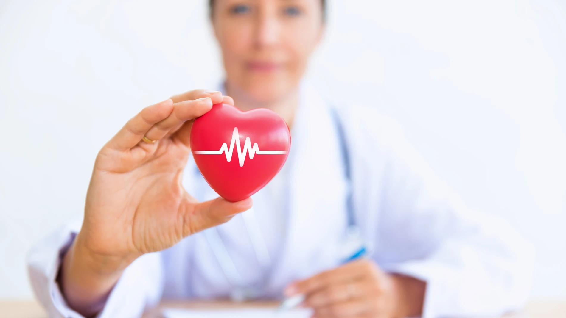 Portrait of woman doctor with holding red heart.