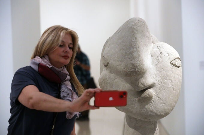 Una visitante se hace un "selfie" junto a una "Cabeza de mujer" (1937) de cemento propiedad del Museo Picasso de Antibes