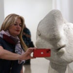 Una visitante se hace un "selfie" junto a una "Cabeza de mujer" (1937) de cemento propiedad del Museo Picasso de Antibes