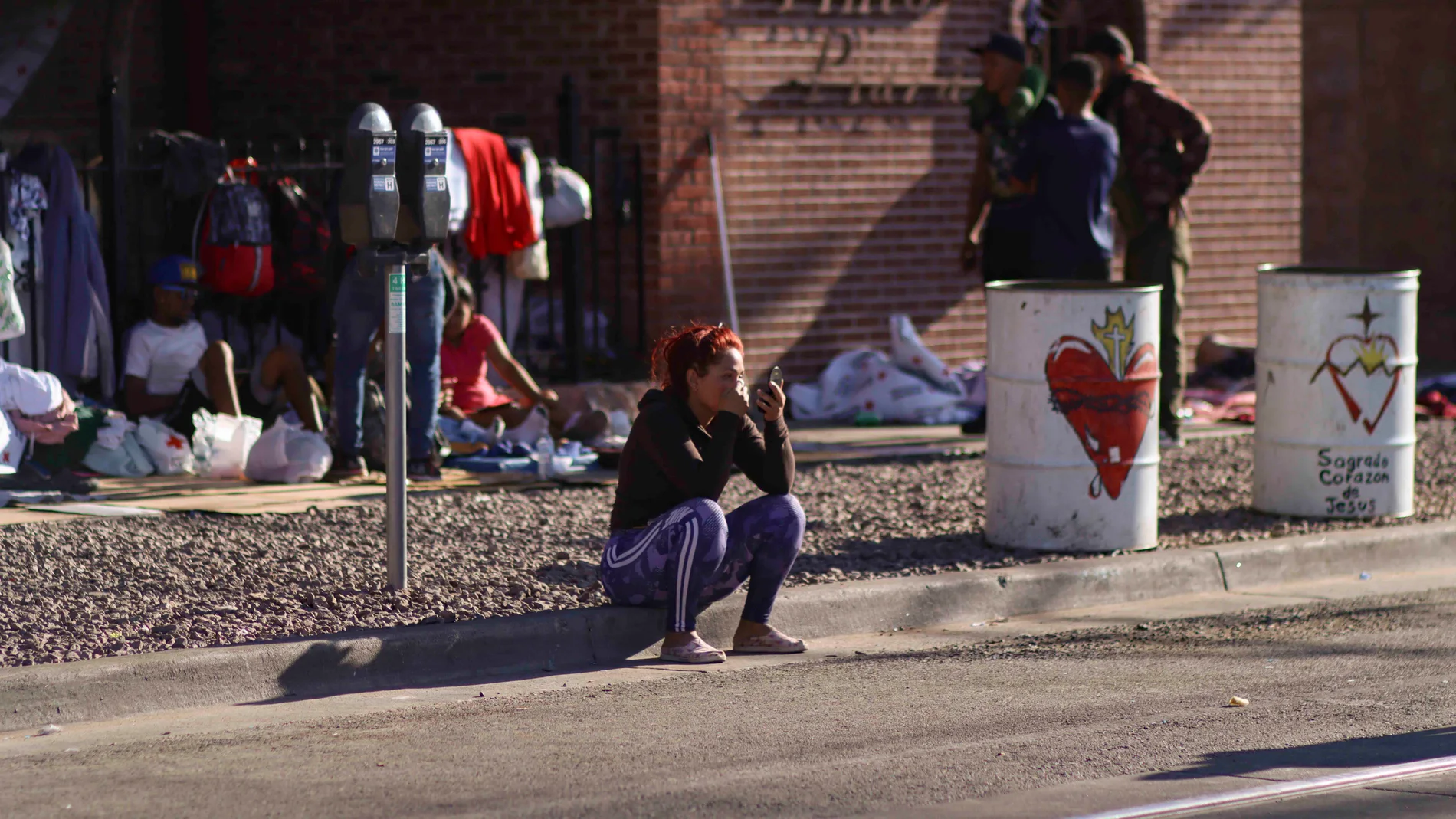  Fotografía de una persona migrante mientras descansa hoy en una acera en El Paso, Texas (EE UU)