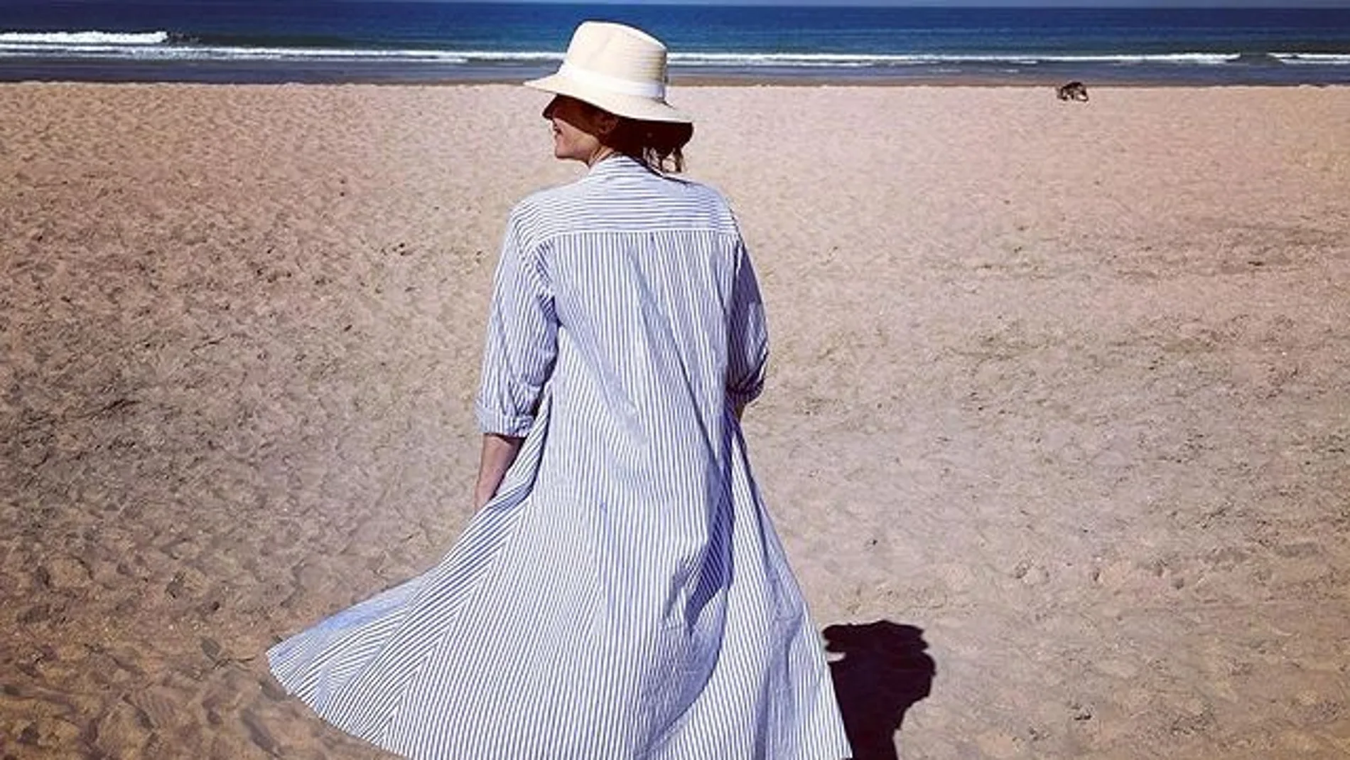 Ana Milán con su camisa larga de rayas en la playa.
