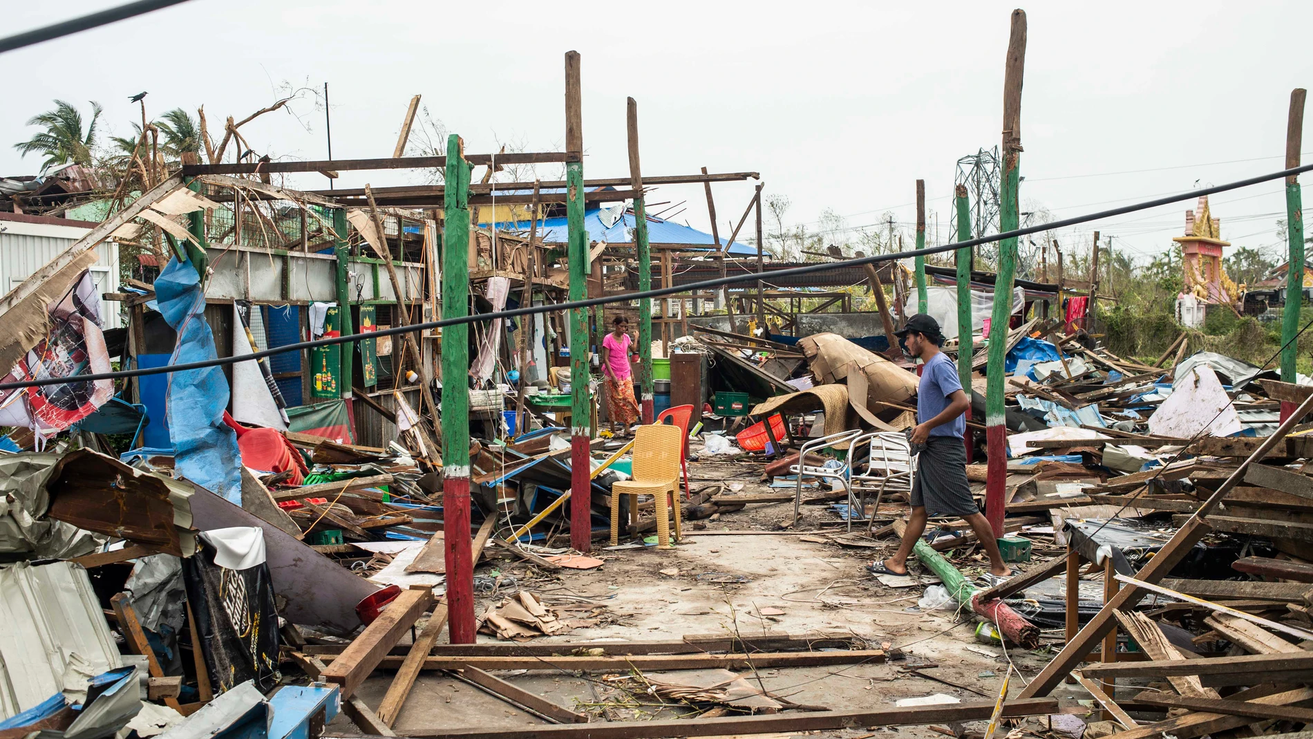 Local residents walk past damaged buildings after Cyclone Mocha in Sittwe township, Rakhine State, Myanmar, Tuesday, May 16, 2023. Myanmar’s military information office said the storm had damaged houses and electrical transformers in Sittwe, Kyaukpyu, and Gwa townships. (AP Photo)