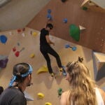 Pati, escaladora de 28 años, y su amigo Miguel, 29 años, ayudan a completar una vía a otro aficionado a la escalada en el rocódromo Arkose en Tetuán