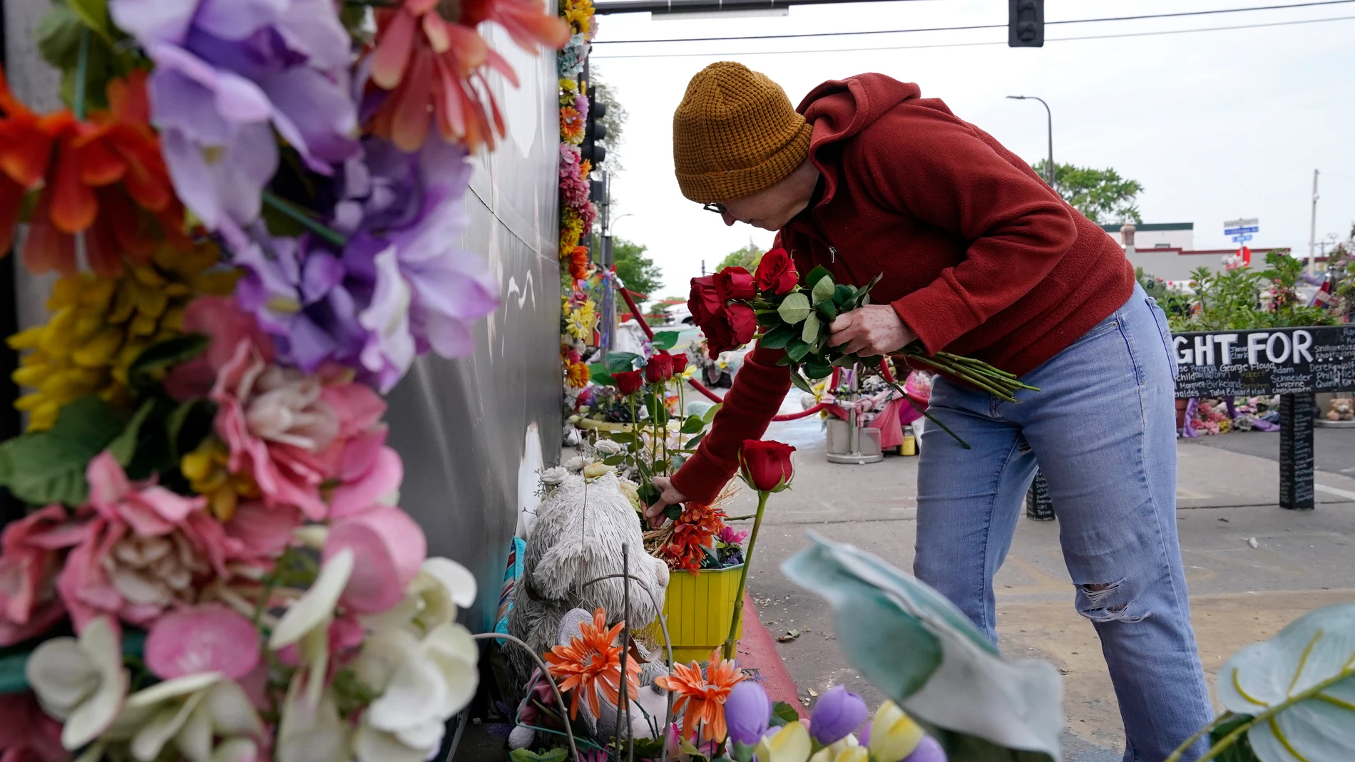 A woman leaves roses along a tribute for George Floyd on the three-year anniversary of his death at George Floyd Square, Thursday, May 25, 2023, in Minneapolis. The murder of Floyd at the hands of Minneapolis police, and the fervent protests that erupted around the world in response, looked to many observers like the catalyst needed for a nationwide reckoning on racism in policing. (AP Photo/Abbie Parr)