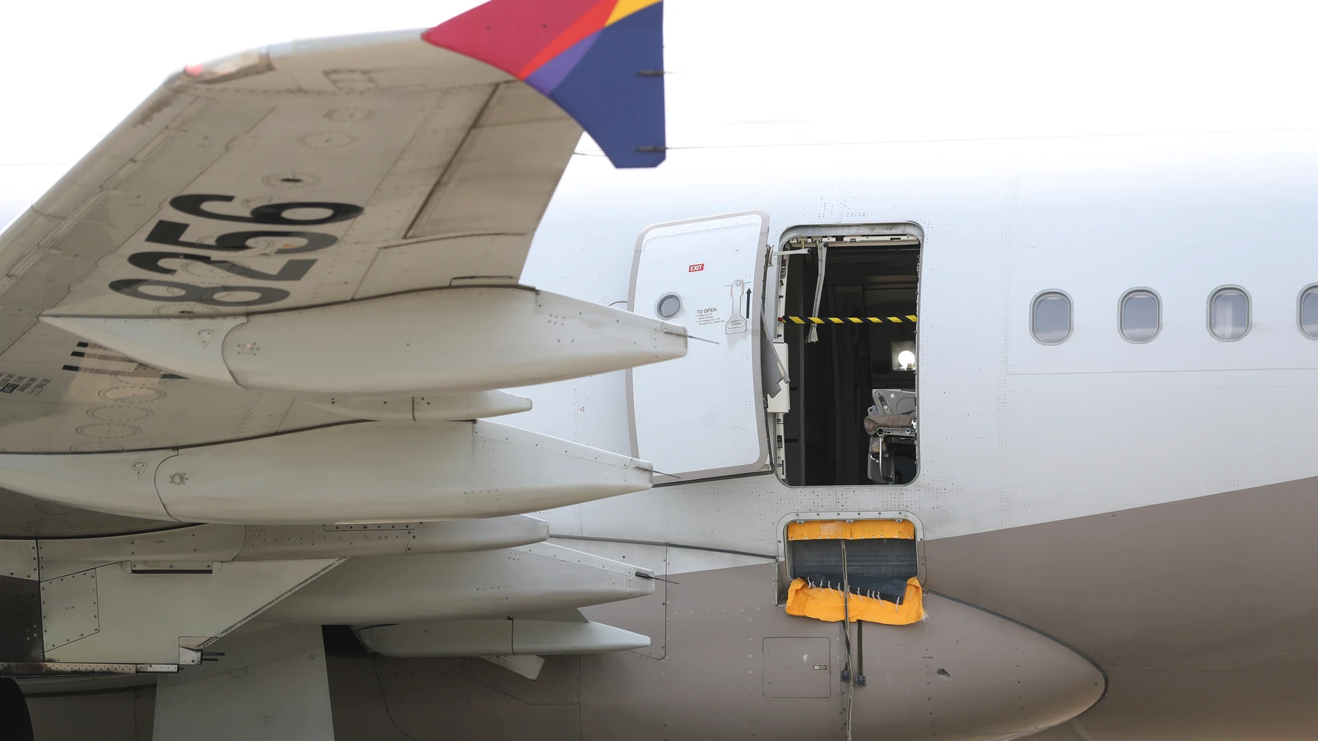 An Asiana Airlines plane is parked as one of the plane's doors suddenly opened at Daegu International Airport in Daegu, South Korea, Friday, May 26, 2023. A passenger opened a door on an Asiana Airlines flight that later landed safely at a South Korean airport Friday, airline and government officials said. (Yun Kwan-shick/Yonhap via AP)