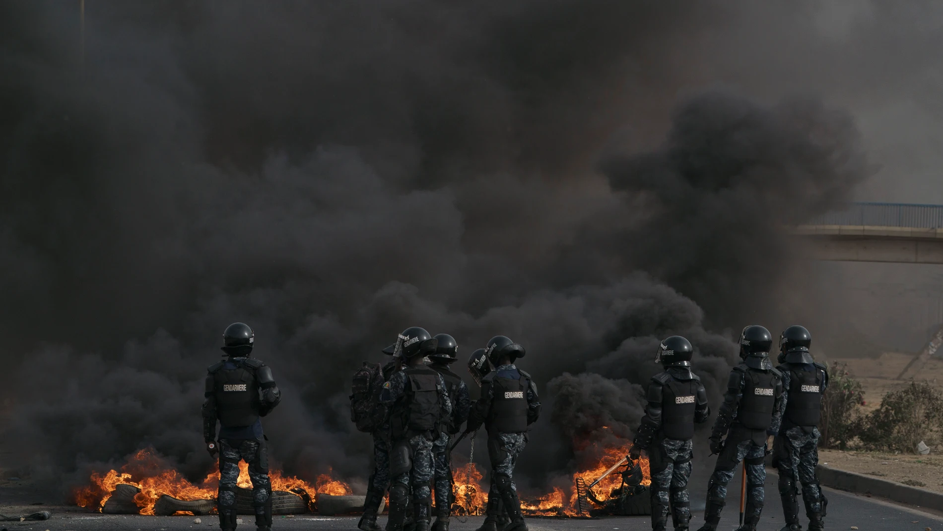 Riot police officers stand in front of tires set on fire during a protest in support of the opposition leader's Ousmane Sonko, in Dakar, Senegal, Monday, May 29, 2023. The clashes came a day after police stopped Sonko's "freedom caravan," traveling from his hometown of Ziguinchor, in the south and where he is the mayor, to the capital, Dakar, where he was forced into a home he has in the city. (AP Photo/Leo Correa)