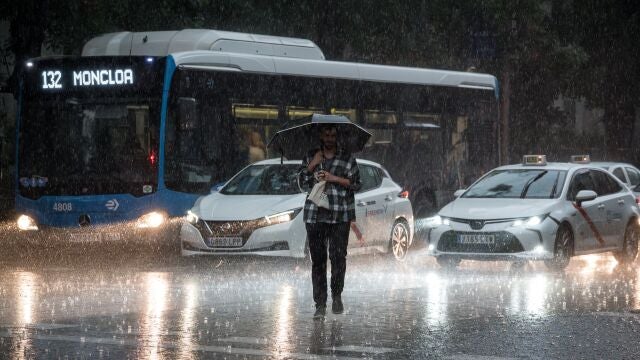Una persona cruza la calle bajo la lluvia en Madrid