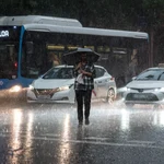 Una persona cruza la calle bajo la lluvia en Madrid