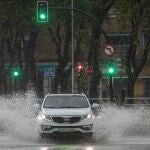 Un vehículo circula por una plaza inundada