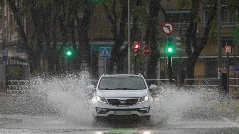 Un vehículo circula por una plaza inundada