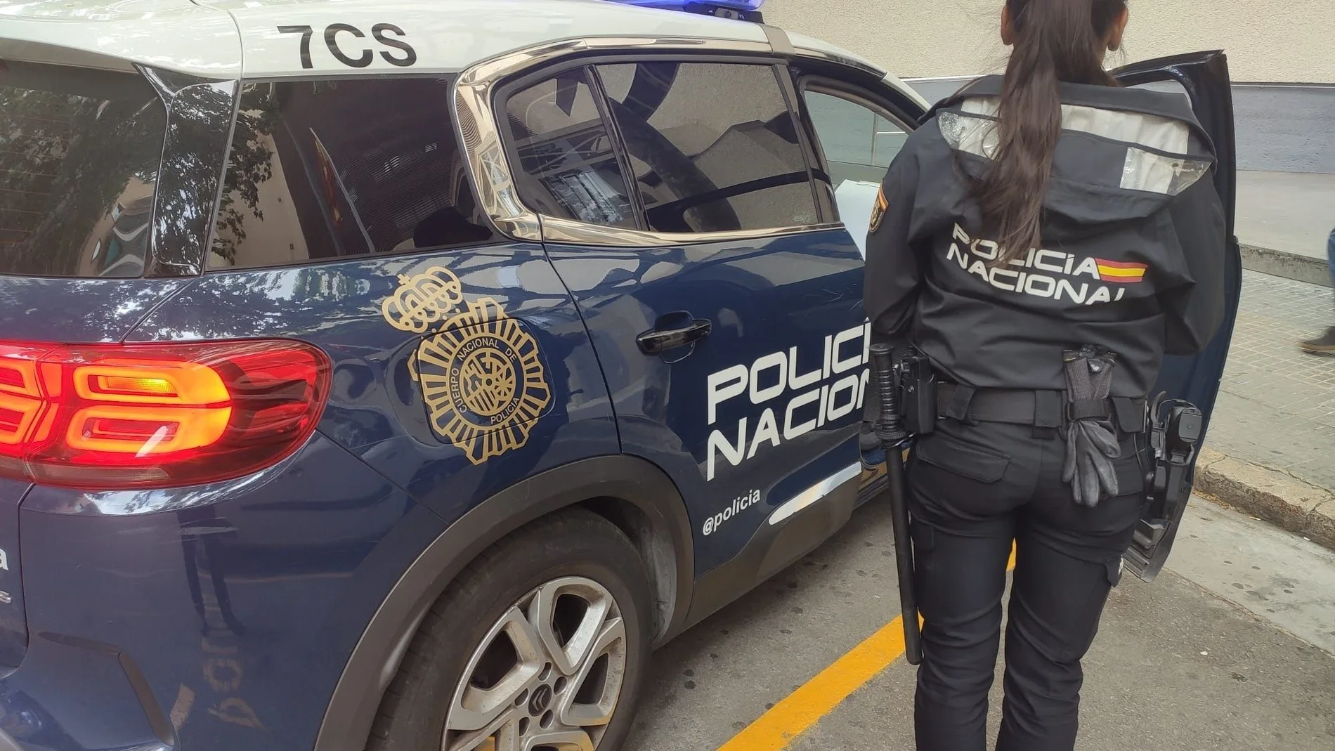 Imagen de archivo de una agente de la Policía Nacional junto al coche