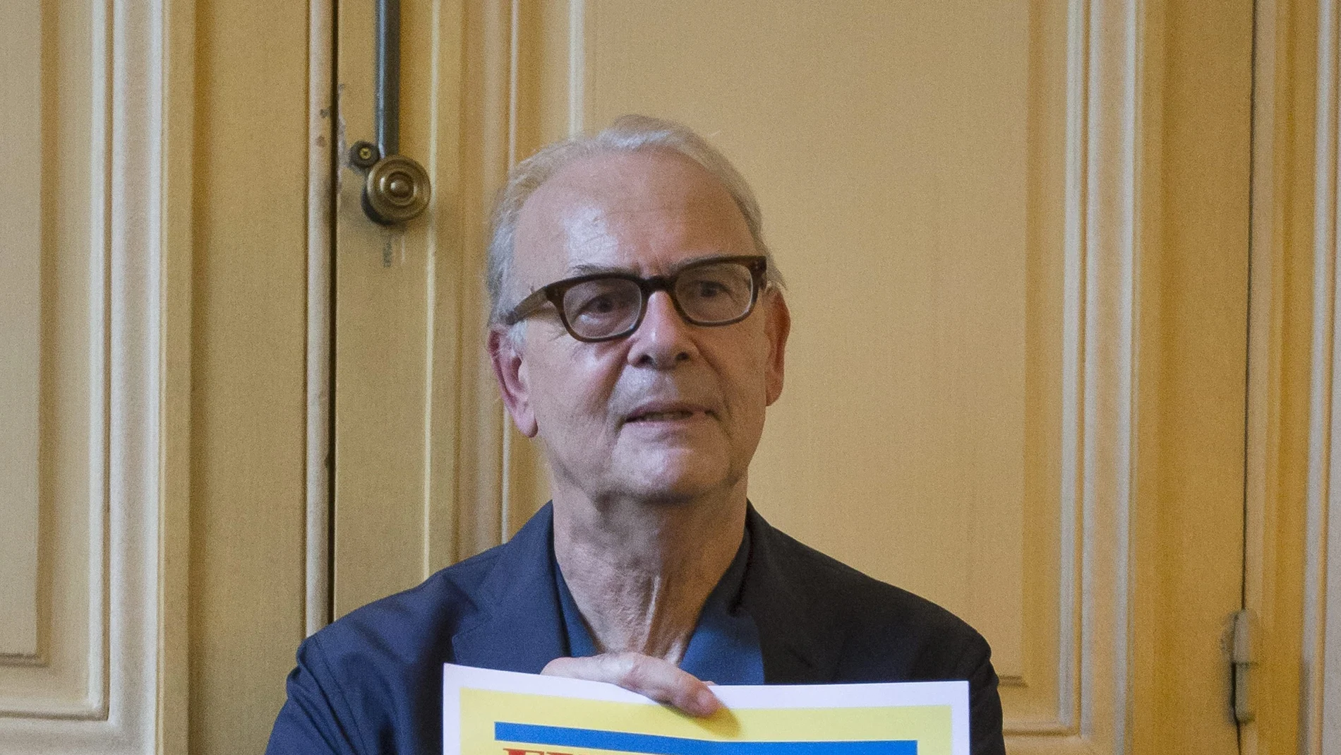 El autor francés Patrick Modiano posa con una portada de un periódico sueco