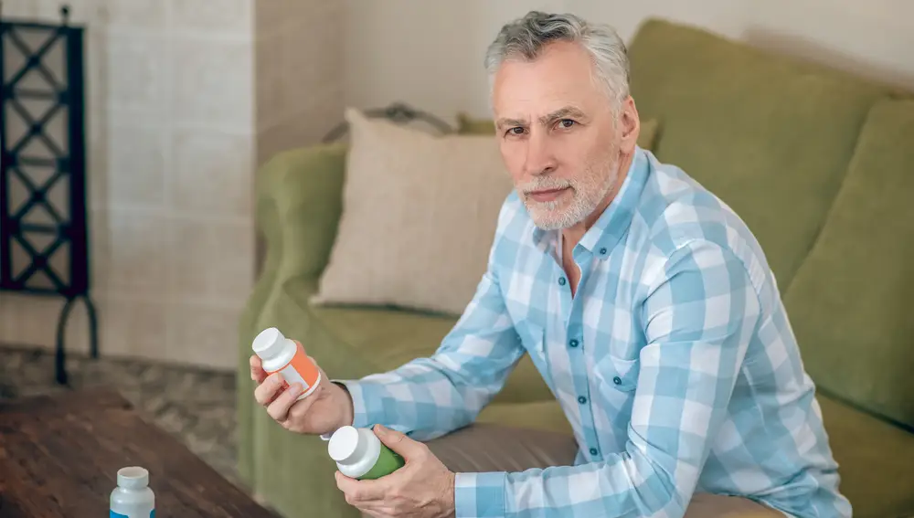Hombre tomando suplementos dietéticos de vitaminas