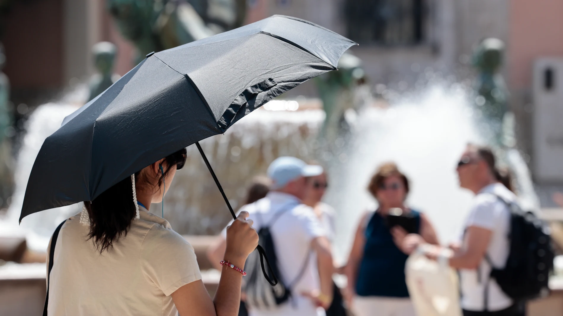Una joven se protege del sol con una sombrilla en el centro de la ciudad de Valancia este viernes. La Agencia Estatal de Meteorología (Aemet) anuncia para este viernes temperaturas máximas de 30 grados en Castelló y València, y 29 en Alicante