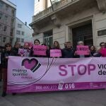 Varias personas con una pancarta en la que se lee: 'Stop violencia de género', participan durante una concentración convocada por la asociación ‘Mujeres en Igualdad', ante la Subdelegación del Gobierno en Lugo