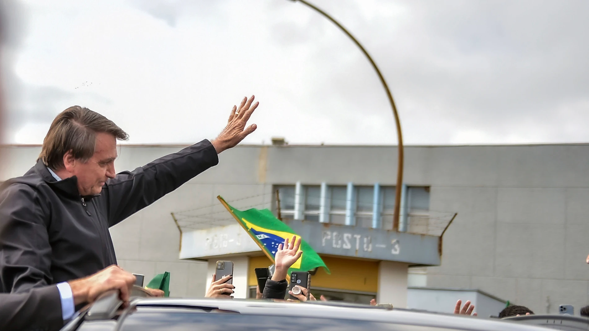 Jair Bolsonaro saluda a sus partidarios a su llegada hoy al aeropuerto de Porto Alegre