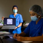 Leyre Herrero muestra la imagen de un embrión mientras la bióloga Rebeca Bravo trabaja junto a las incubadoras antiguas, una especie de cajas azules y negras, y modernas, blancas y verdes con una pantalla