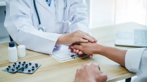 Un médico y su paciente en la sala de un hospital
