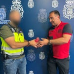 Un agente de la Policía entrega un palomo de competición a su dueño