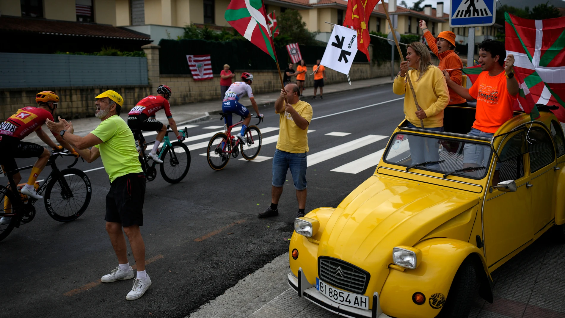 Fans on a classic Citroen 2CV wave flags during the first stage of the Tour de France cycling race over 182 kilometers (113 miles) with start and finish in Bilbao, Spain, Saturday, July 1, 2023. (AP Photo/Daniel Cole)
