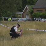 Police officers set up cordon line as a car crashed into a primary school building in Wimbledon, London, Thursday, July 6, 2023.