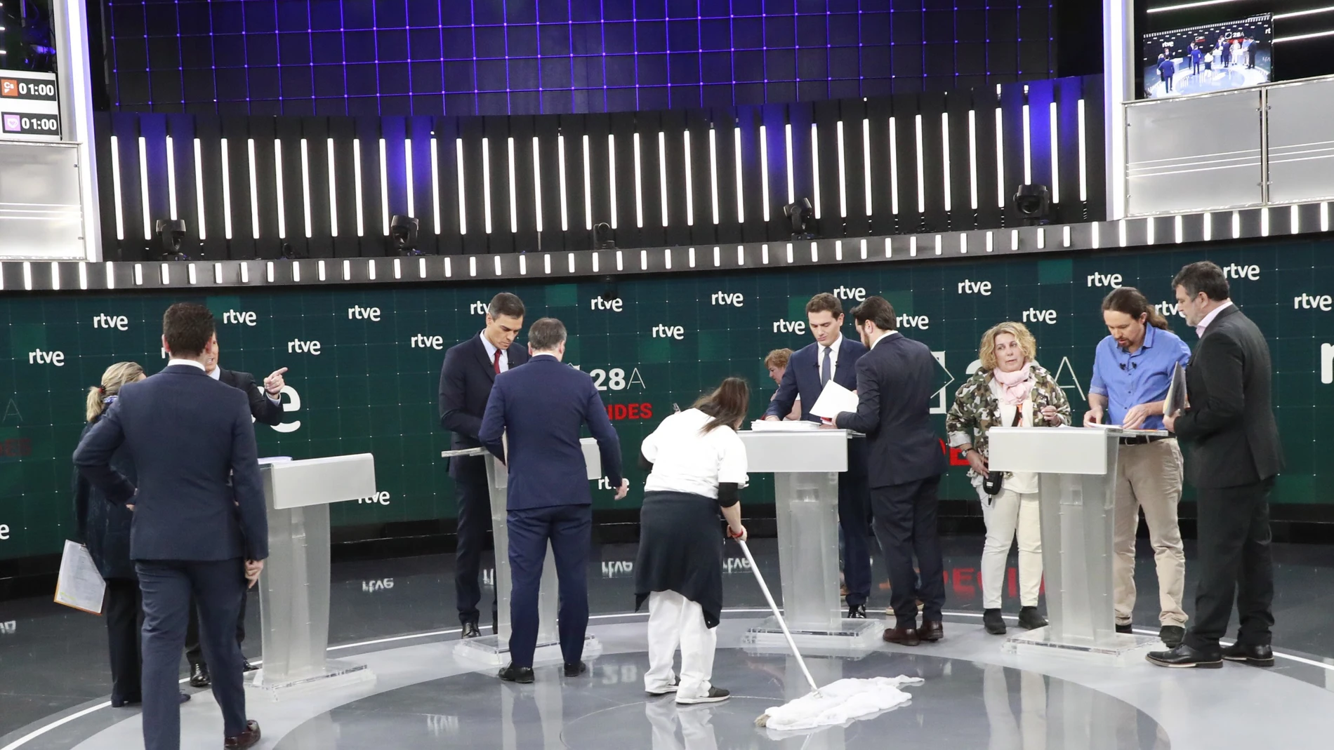 Los candidatos hablan con sus asesores en una pausa del debate de 2019