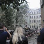 People watch as emergency service workers continue to search for victims after a Russian missile attack in Lviv, Ukraine, Thursday, July 6, 2023.