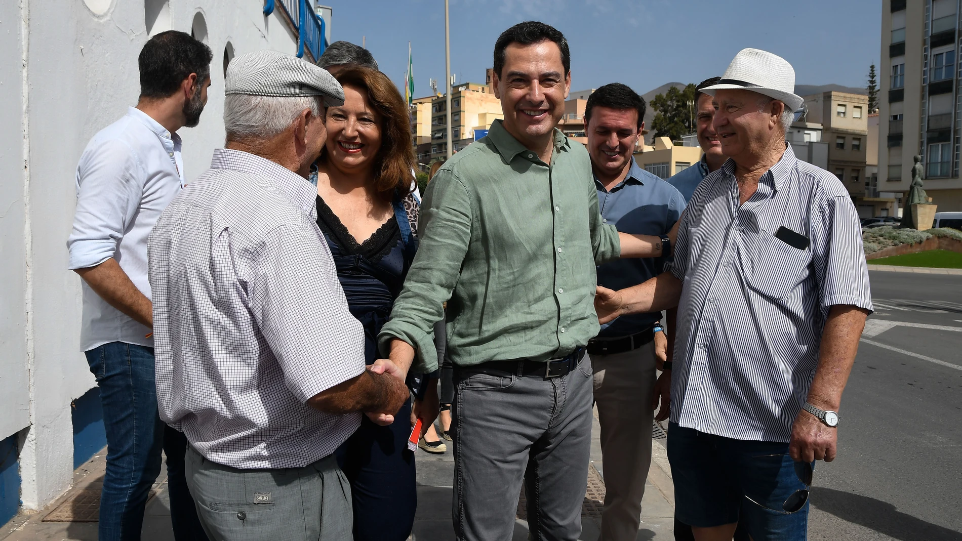 ADRA (ALMERÍA), 09/07/2023. - El presidente del PP en Andalucía, Juanma Moreno (c), saluda a varios simpatizantes a su llegada a un acto con militantes en Adra, Almería. EFE / Carlos Barba