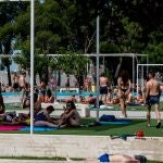 Varias personas disfrutan y se relajan este domingo en una piscina municipal en La Elipa, intentando paliar la ola de calor de esta jornada de julio. 