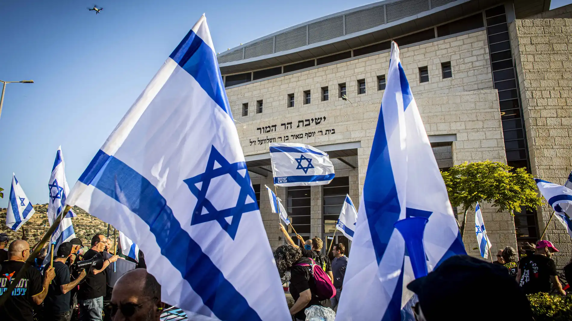 July 5, 2023, Jerusalem, Israel: Anti reform protestors wave Israeli flags during a demonstration. Over 200 protesters against the government's judicial overhaul demonstrated in front of Har Hamor yeshiva headed by Rabbi Zvi Tau, the protesters said that the Yeshiva, symbolizes the messianic stream that is leading the regime coup. 05/07/2023