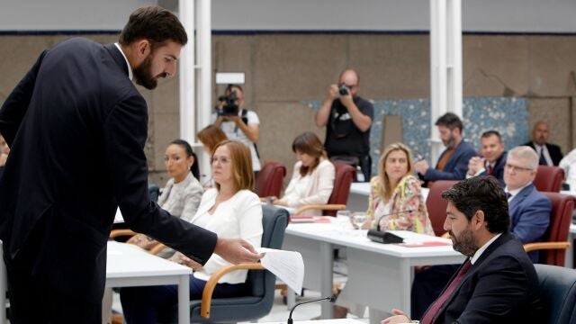 El portavoz de VOX, José Angel Antelo (i), entrega al candidato del PP a la presidencia, Fernando López Miras, el documento que incluye el pacto de gobierno 