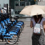 Una viandantes se protege del sol con un paraguas mientras camina por el centro de Madrid