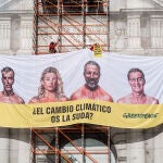 Greenpeace cuelga una lona en la Puerta de Alcalá con la cara de los candidatos a las elecciones del 23J