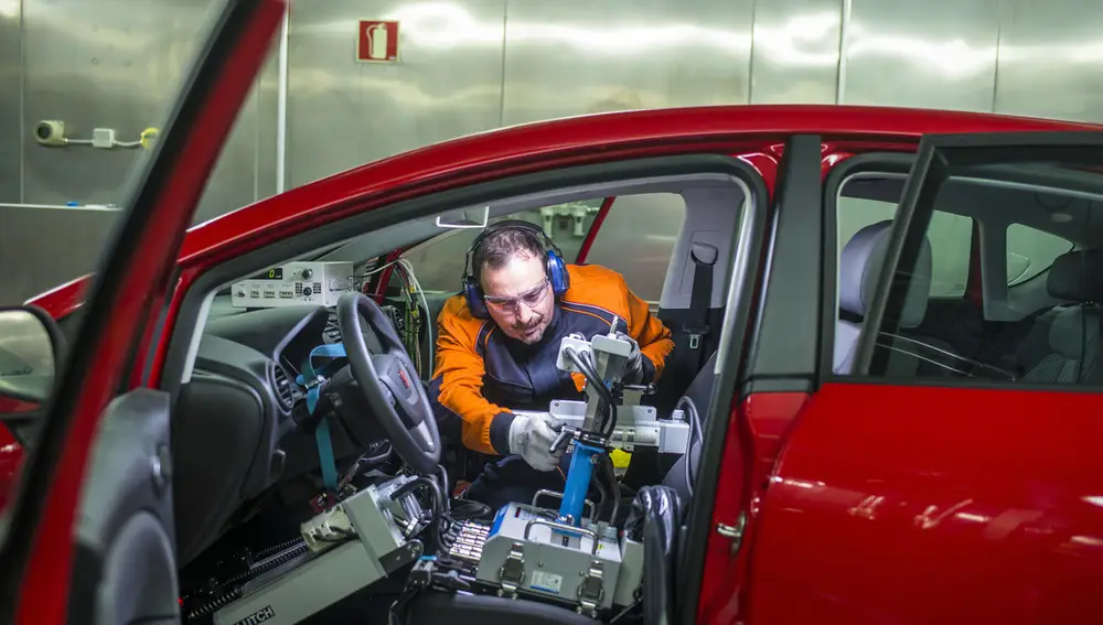 Un técnico de laboratorio realiza ajustes al robot que está en el interior del coche, en Repsol Technology Lab
