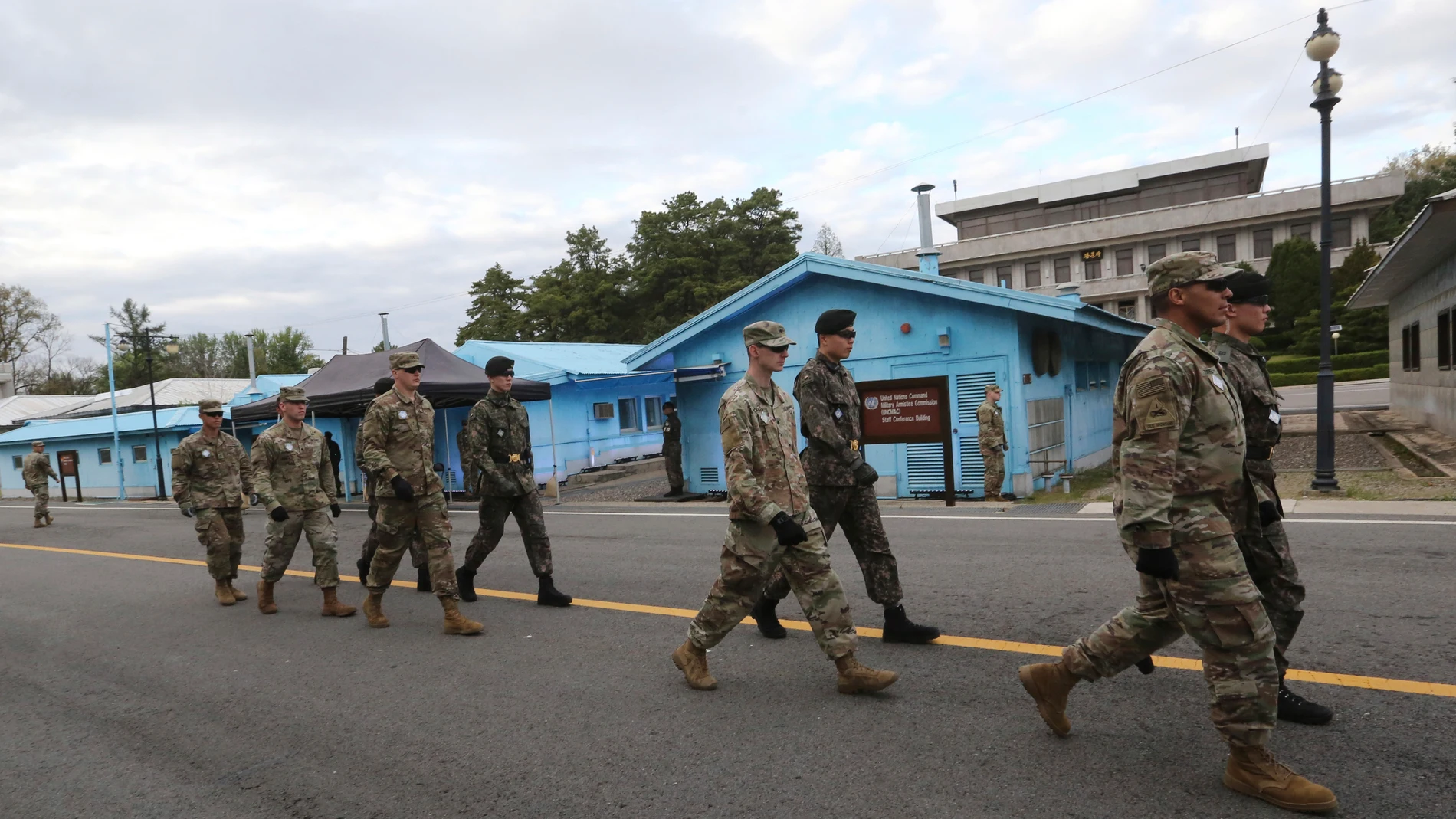 FILE - South Korean and U.S. Army soldiers, wearing grey uniforms, patrol during a rehearsal to mark the first anniversary of a summit between South Korean President Moon Jae-in and North Korean leader Kim Jong Un, at the border village of Panmunjom in the demilitarized zone (DMZ) between the two Koreas in Paju, South Korea on April 26, 2019. An American has crossed the heavily fortified border from South Korea into North Korea, the American-led U.N. Command overseeing the area said Tuesday, ...