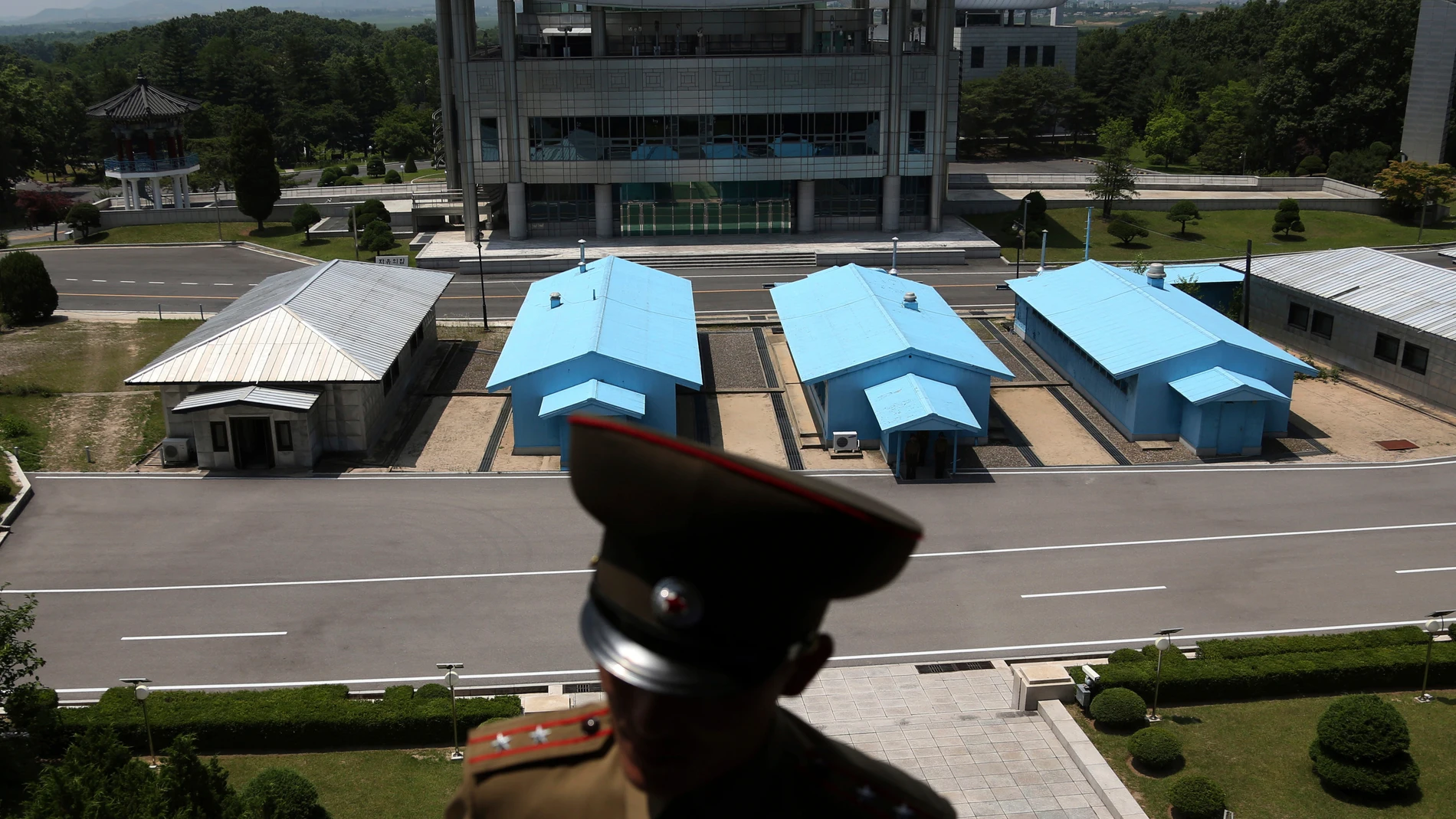 FILE - A South Korean building complex is seen in the background as North Korean soldiers guard the truce village at the Demilitarized Zone (DMZ) which separates the two Koreas in Panmunjom, North Korea, June 20, 2018. An American has crossed the heavily fortified border from South Korea into North Korea, the American-led U.N. Command overseeing the area said Tuesday, July 18, 2023, amid heightened tensions over North Korea's nuclear program. (AP Photo/Dita Alangkara, File)