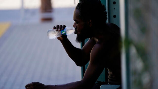 Un hombre bebe agua a la sombra en Phoenix