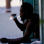 Un hombre bebe agua a la sombra en Phoenix