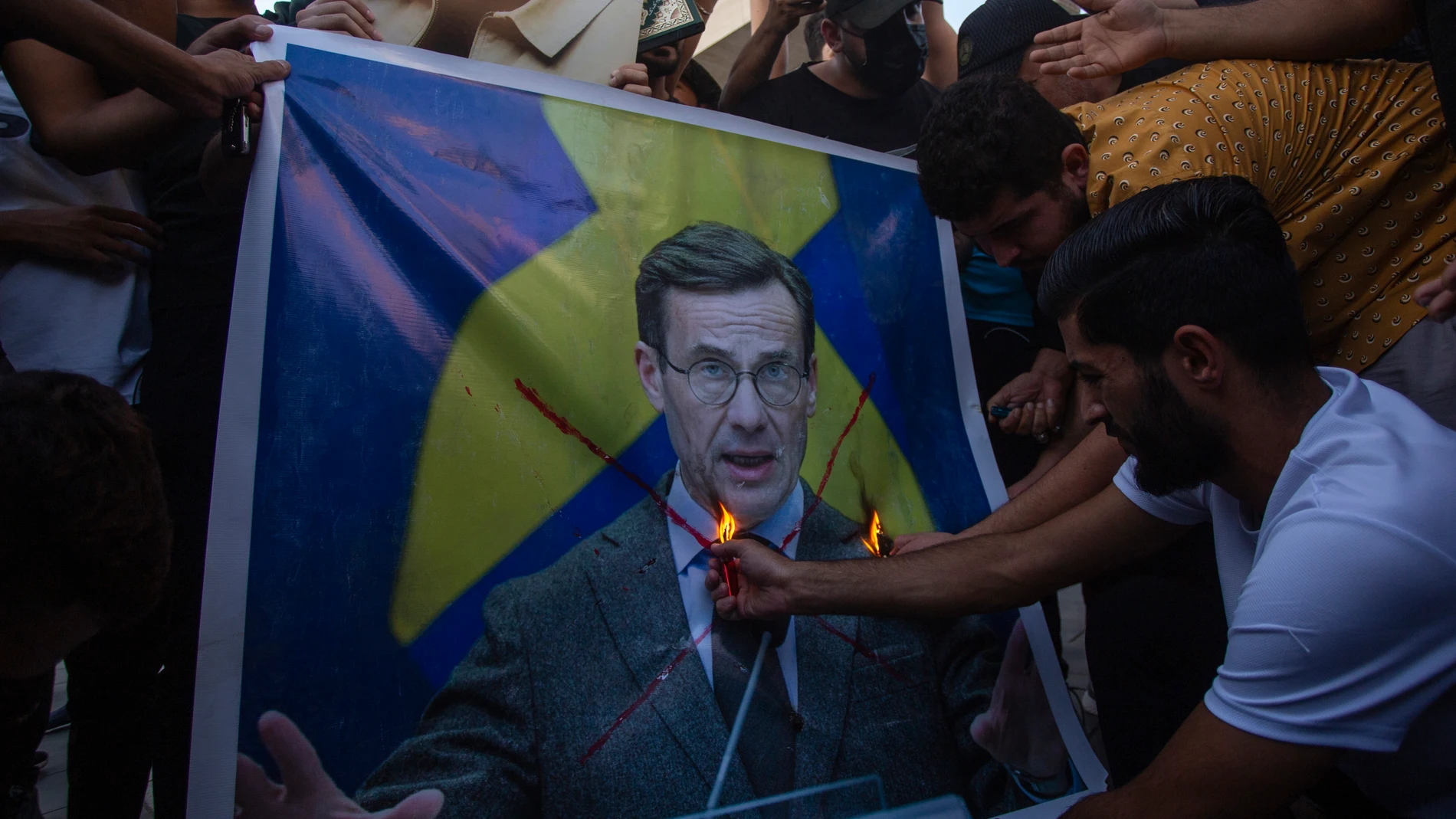 Iraquíes queman una imagen del primer ministro sueco, Ulf Krsitersson, en la Plaza Tahir de Bagdad