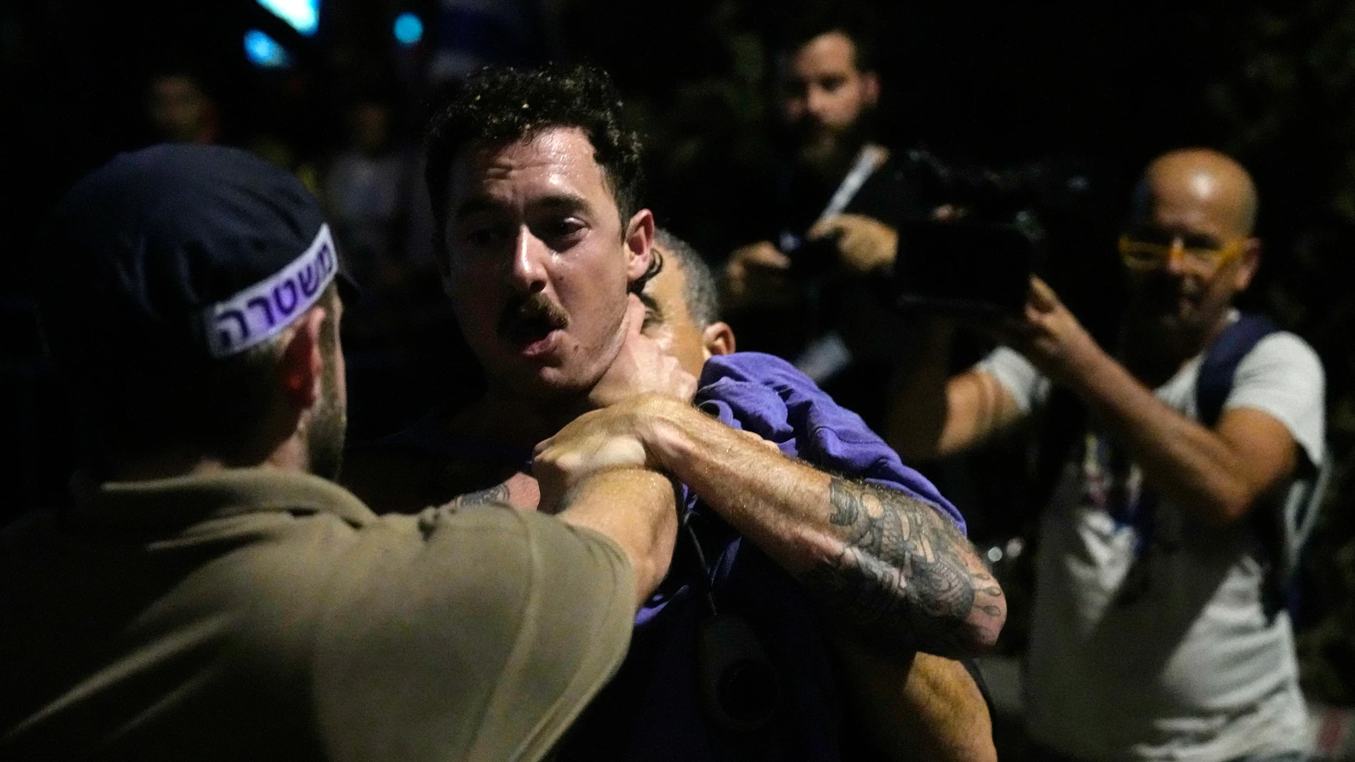 Police forcibly detain an Israeli protesting against plans by Prime Minister Benjamin Netanyahu's government to overhaul the judicial system, in Tel Aviv, Thursday, July 20, 2023. (AP Photo/Ariel Schalit)