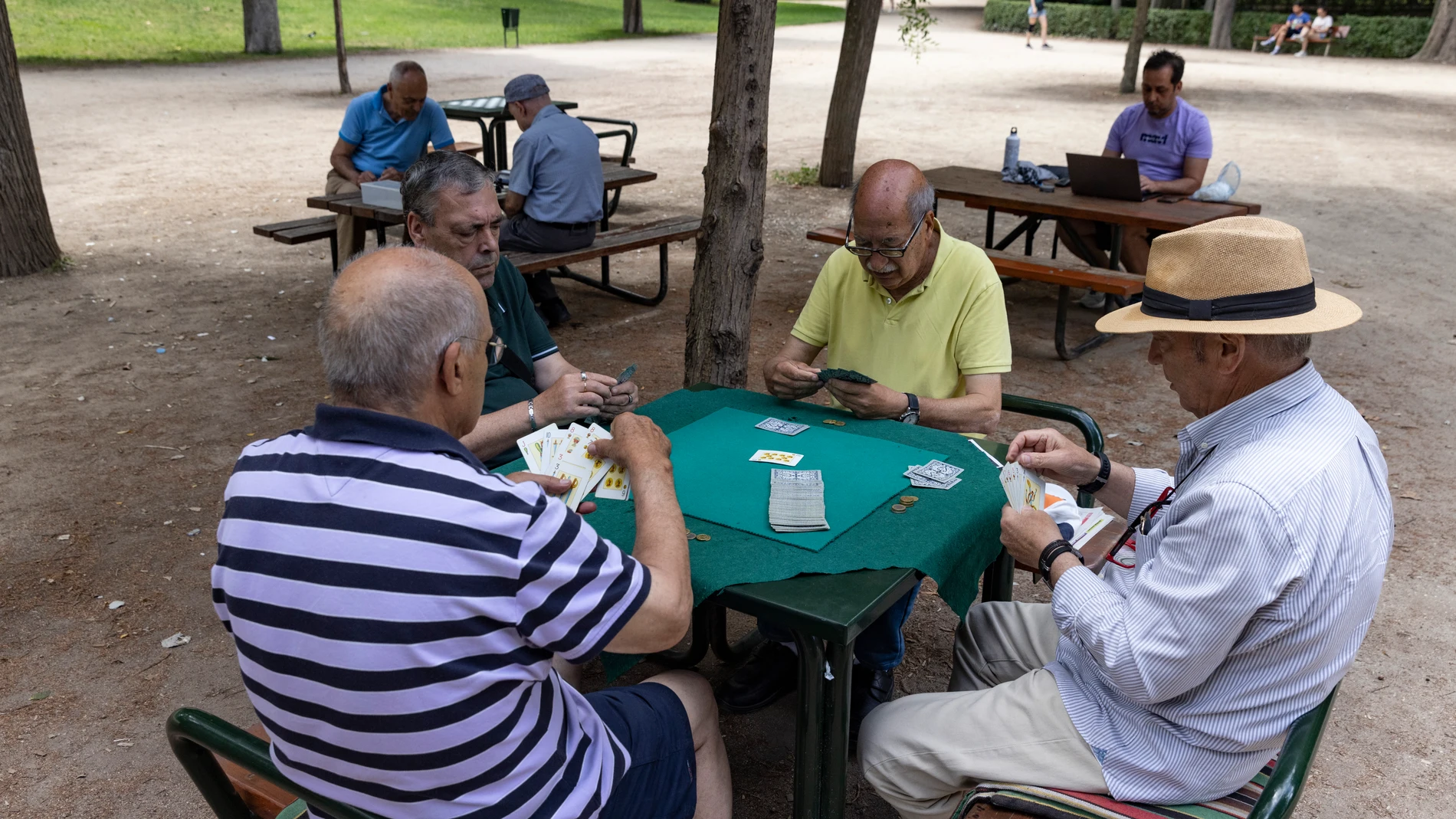 Unos jubilados juegan a las cartas en el madrileño parque del Retiro