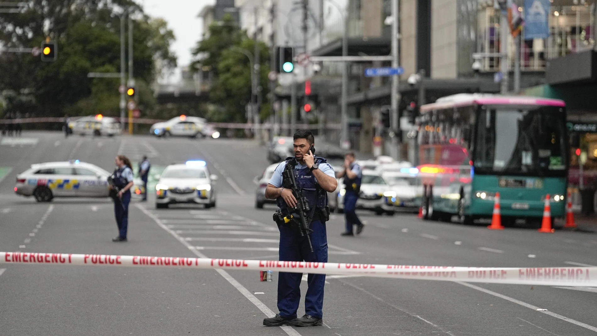 Armed New Zealand police officers stand at a road block in the central business district following a shooting in Auckland, New Zealand