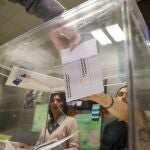 Una persona introduce el voto en a urna 
