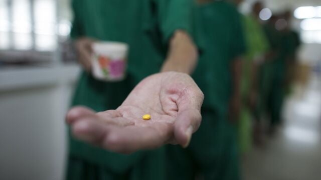 Patients line up to receive medicine in a rehabilitation program.