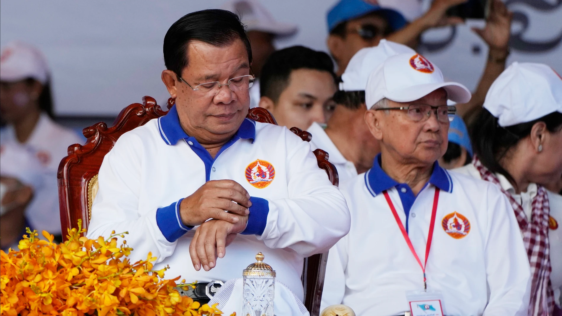 Cambodia Prime Minister Hun Sen, front left, also President of Cambodian People's Party, looks at his watch during his party election campaign in Phnom Penh Cambodia, on July 1, 2023. Longtime Cambodian leader Hun Sen said Wednesday, July 26, he will step down in three weeks as prime minister and hand the position to his oldest son, who won his first seat in Parliament in Sunday's election. (AP Photo/Heng Sinith)