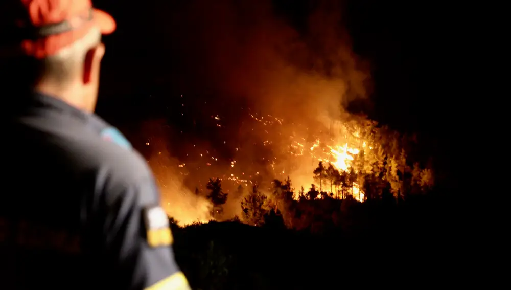 Un bombero observa un incendio forestal en la aldea de Asklipio, en la isla de Rodas. 20.000 vecinos y turistas han sido evacuados de zonas amenazadas por los incendios forestales en esta isla bonita isla del Mar Egeo