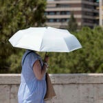 Una persona se protege este jueves de las altas temperaturas con un parasol. La Conselleria de Sanidad ha activado este jueves el nivel de riesgo rojo (alto) por calor en los municipios de Jalance y Jarafuel, en la comarca del Valle de Cofrentes-Ayora, en Valencia